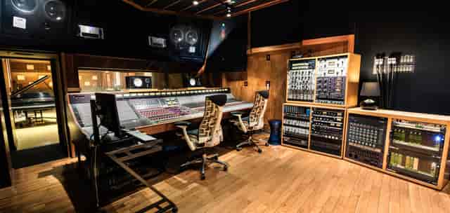 Professional audio recording studio with large mixing console for events and productions.