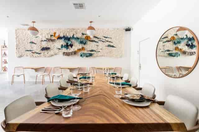 Stylish event space with wooden table, teal accents for upscale meetings and private dinners.