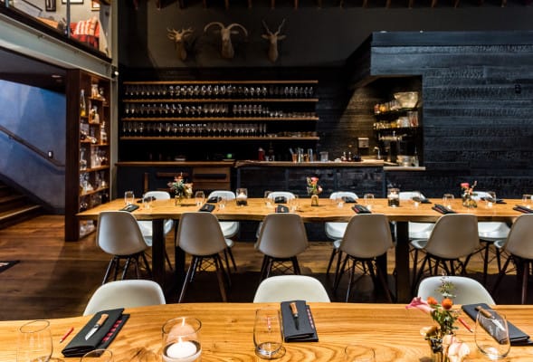 Stylish Mezzanine dining space with wooden tables for intimate gatherings and corporate events.