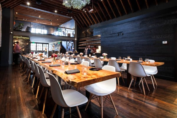 Stylish Mezzanine dining space with wooden table for corporate events and gatherings.