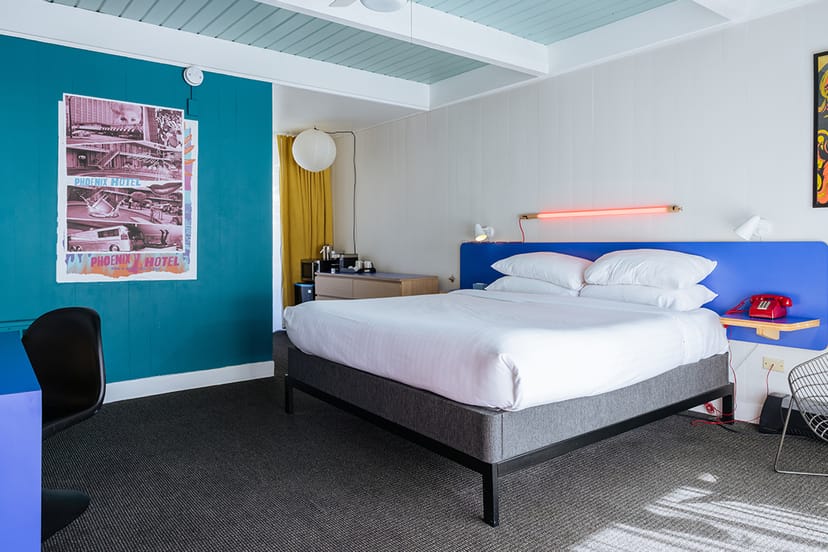 Vibrant hotel room in Phoenix for meetings and retreats, featuring a cozy bed and modern decor.