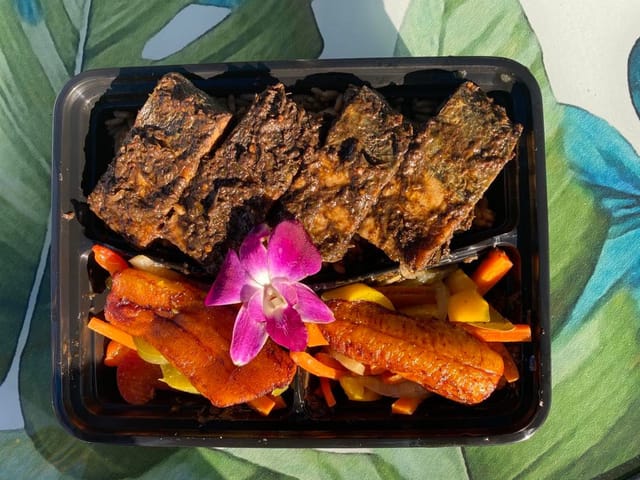 Grilled protein dish with vibrant veggies at Cocobreeze Caribbean Restaurant for events.