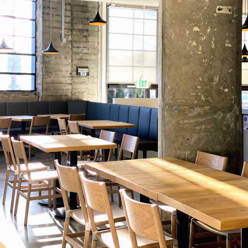 Outdoor seating at Ernest with wooden tables, ideal for casual meetings and networking.