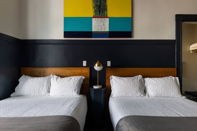 Modern hotel room with two beds, ideal for conferences and gatherings.