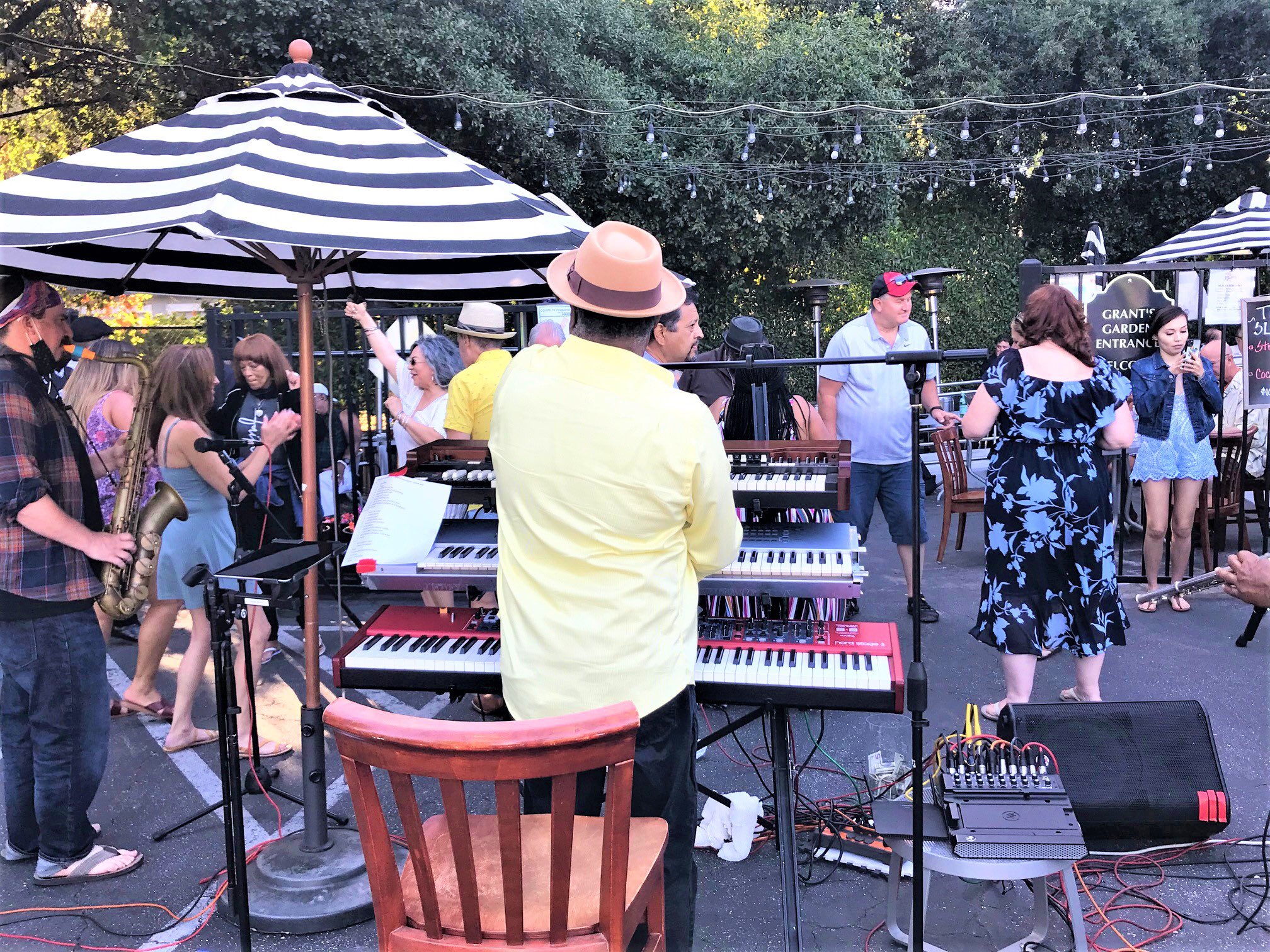 Lively Beer Garden event with band, striped umbrellas, and vibrant crowd.