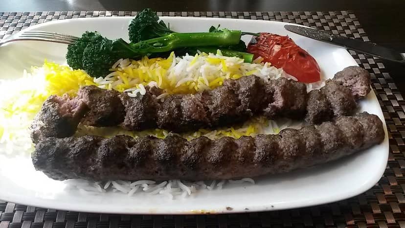 Grilled meat skewers with yellow rice, ideal for event catering and guest experience.