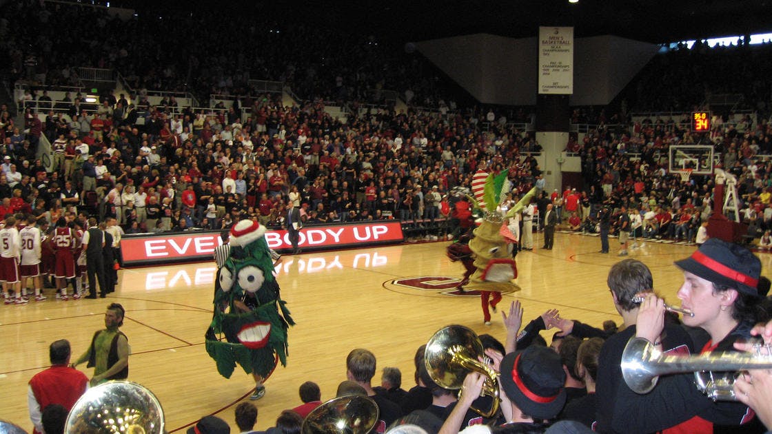 Maples Pavilion at Stanford, lively sports event with mascots and band energizing crowd.