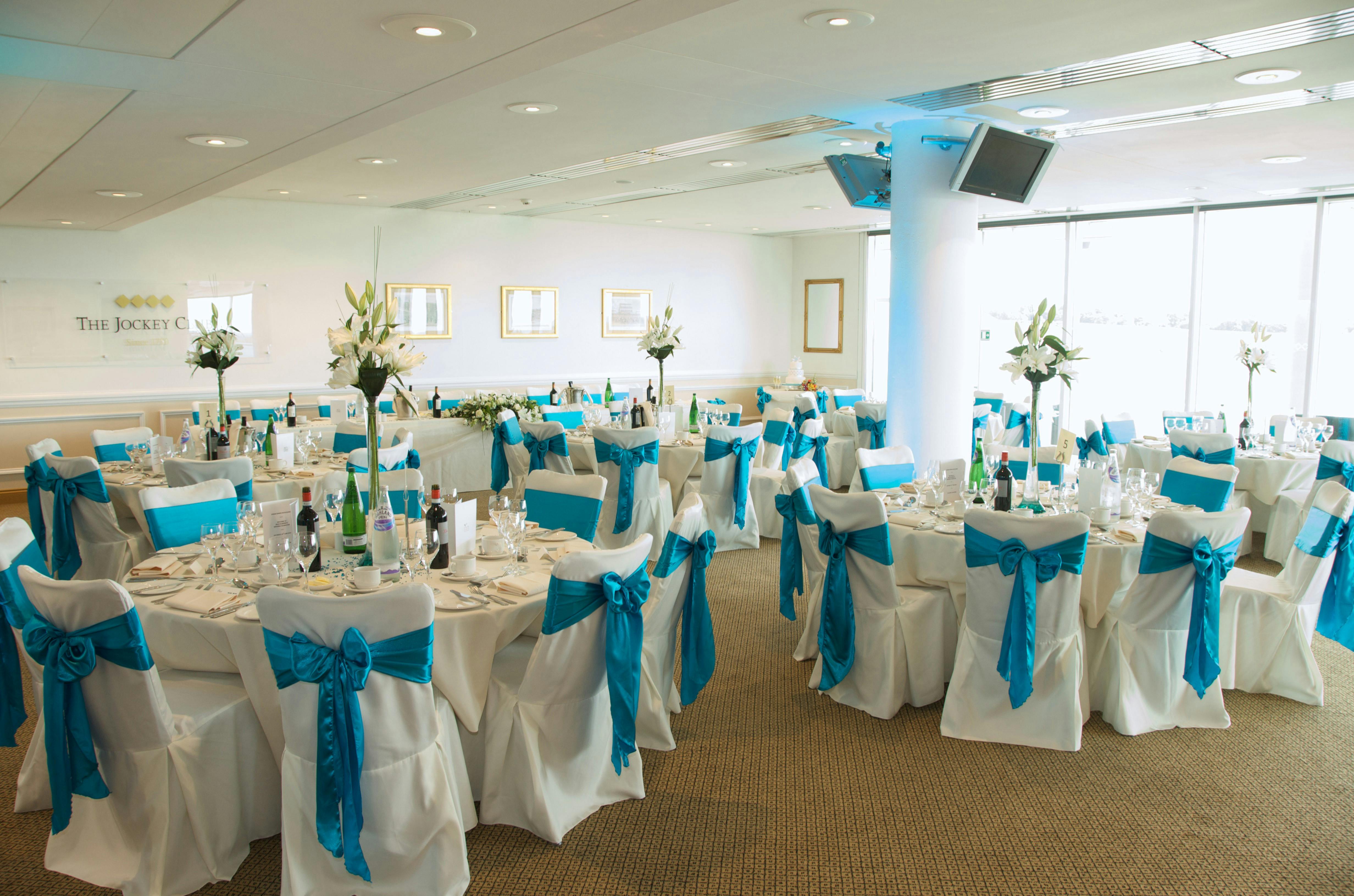 Elegant event space at Epsom Downs Racecourse with round tables, ideal for weddings and corporate events.