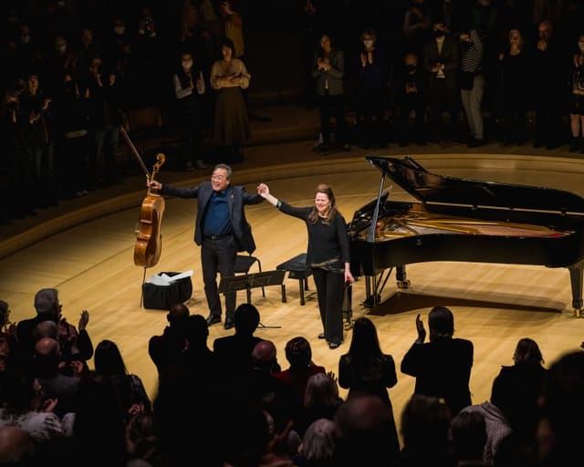 "Campbell Recital Hall live performance with audience standing ovation, showcasing teamwork."