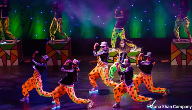 Intensive Training Class dancers in colorful outfits performing dynamic choreography on stage.