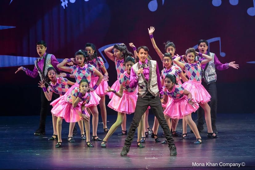 Young dancers in colorful costumes performing at Mona Khan Company's training class.
