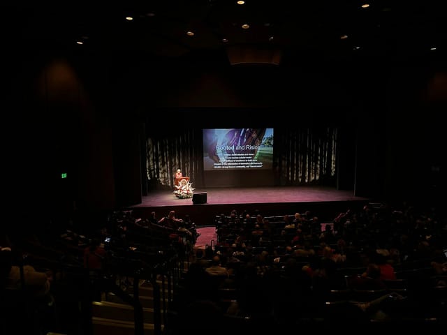 Mission Santa Clara event with speaker on stage in engaging theater setting.