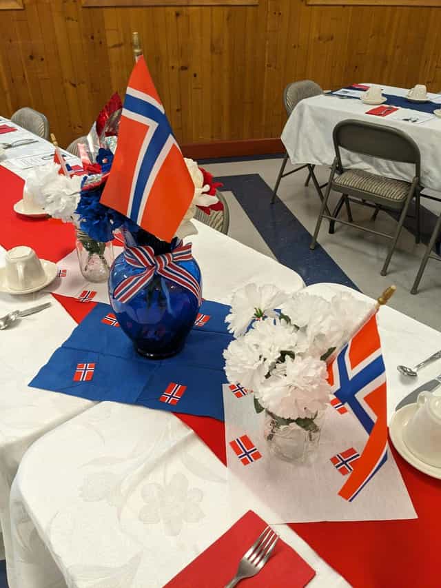 Banquet Hall table with Norwegian decor, flowers, ideal for cultural celebrations.