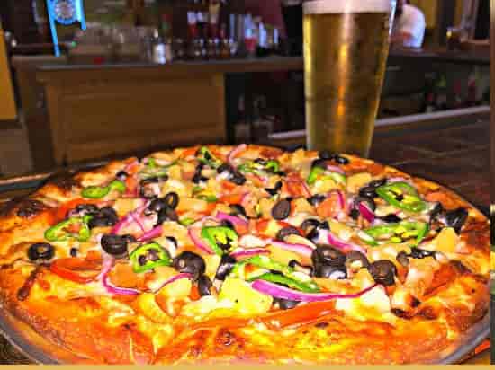 Vibrant pizza with vegetables and beer at Grill Em Pizza & Sports Bar for events.
