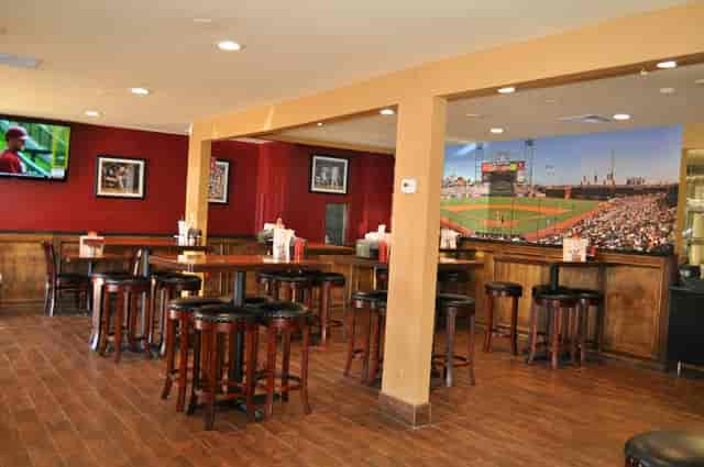 Versatile event space at Grill Em Pizza & Sports Bar with wooden tables, ideal for gatherings.