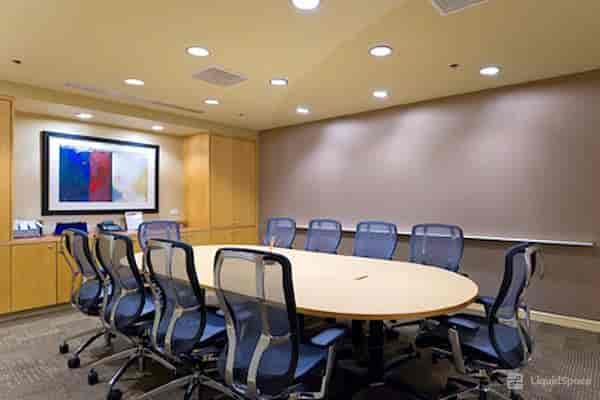 Modern conference room with oval table, ideal for meetings and presentations.