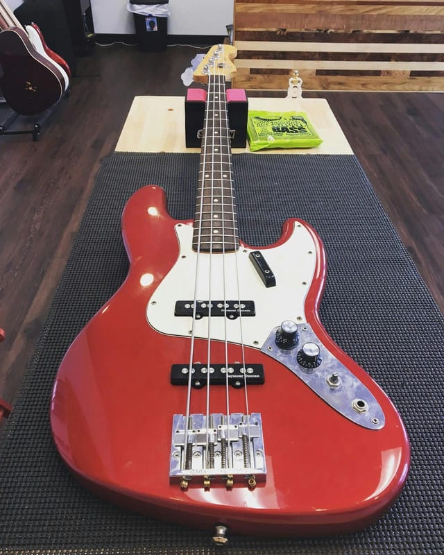 Vibrant red bass guitar in Band Practice Studio for engaging live music events.