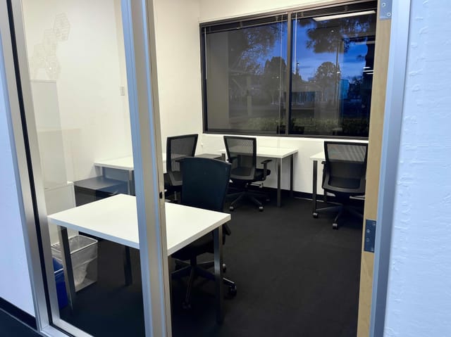Modern minimalist meeting space with flexible desks for collaboration and brainstorming.