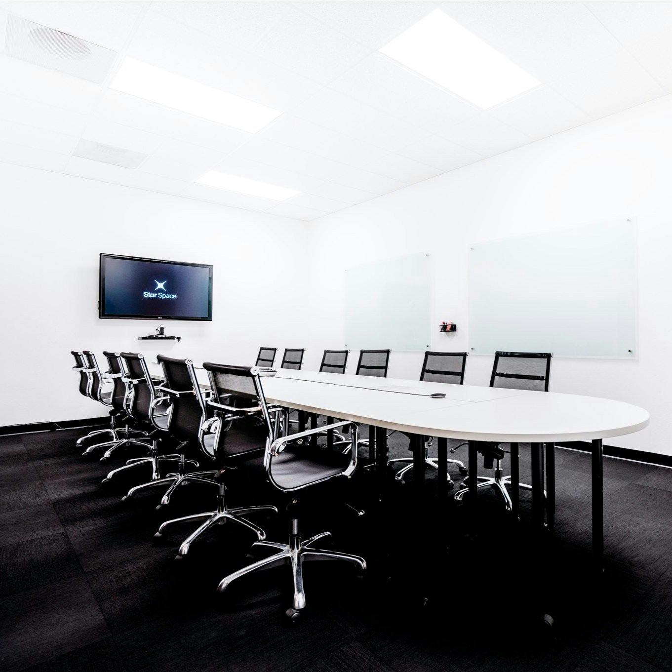 Modern conference room with oval table, ideal for meetings and events.