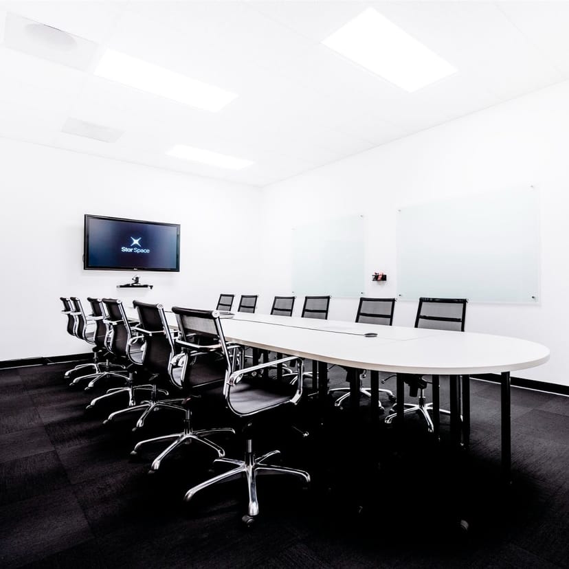 Modern conference room with oval table, ideal for meetings and events.
