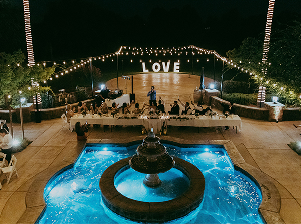 Outdoor wedding venue with illuminated "LOVE" sign and elegant table setup at Wolfe Heights Winery.