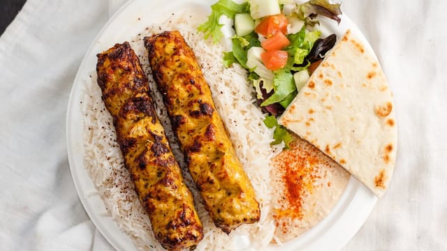 Grilled kebabs with rice and salad at Sophie's Mediterranean Grill catering event.