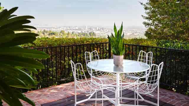 Outdoor patio with round table and cityscape, ideal for creative meetings and gatherings.