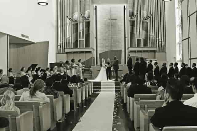 Wedding ceremony in modern church with elegant decor and floral accents.