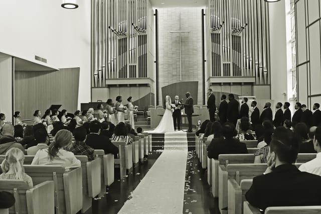 Wedding ceremony in modern church with elegant decor and floral accents.
