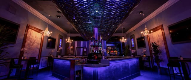 Elegant OPAL Nightclub bar with purple lighting, perfect for cocktail receptions and networking.