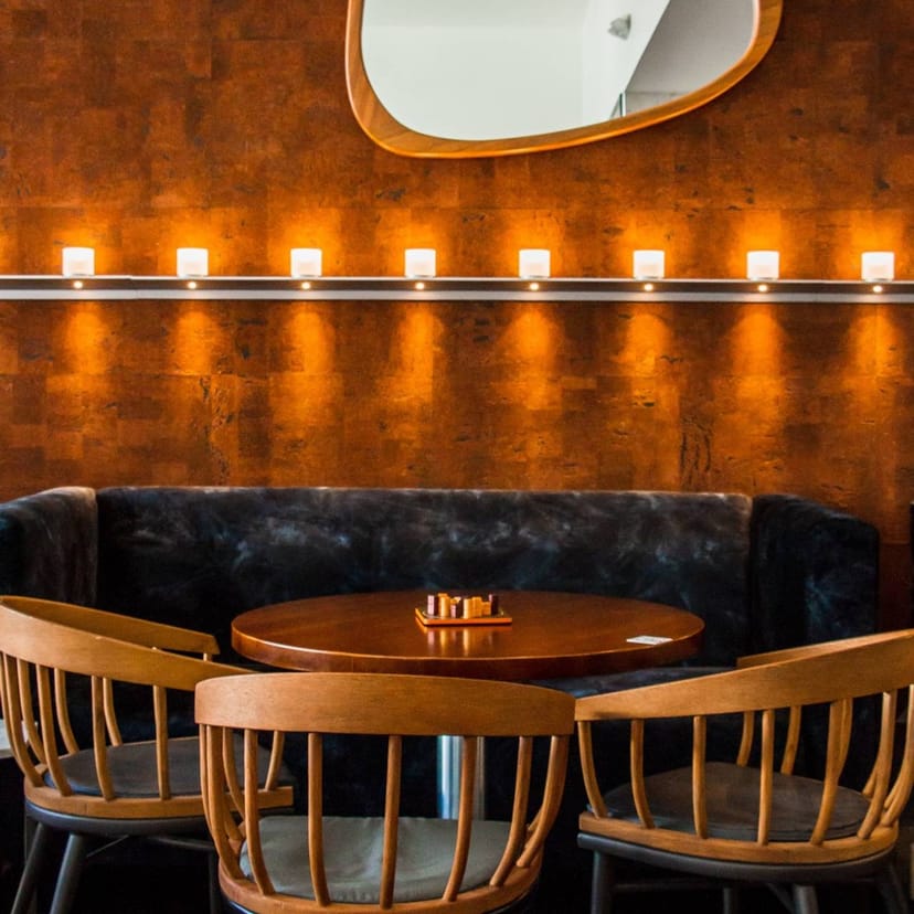 Cozy cocktail bar meeting space with circular wooden table for intimate gatherings.