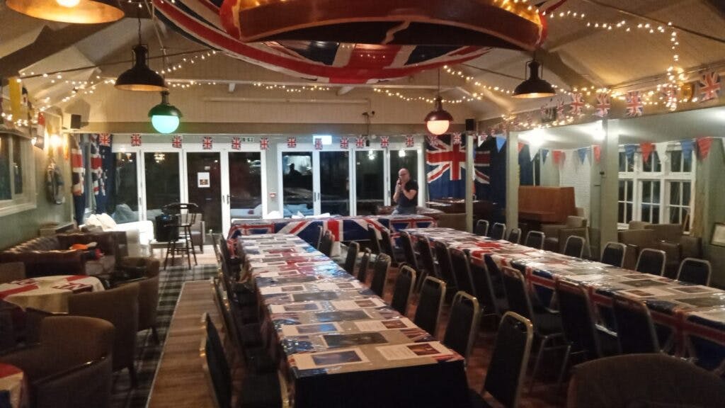 Dry dock at Hurlingham Yacht Club, decorated for a festive dining event with British flags.