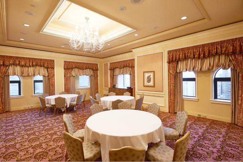 Elegant meeting space in Fairmont Royal York with round tables and luxurious chandelier.