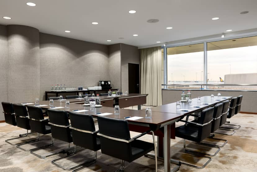 Modern meeting room at Sheraton Amsterdam with large table, ideal for conferences.