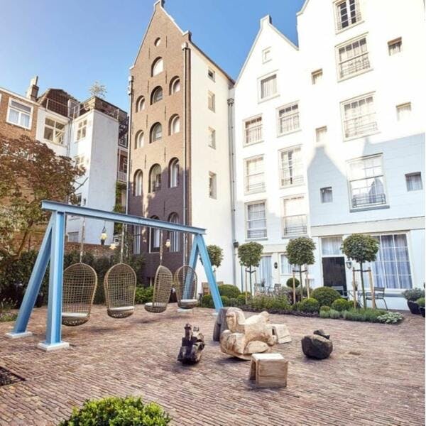 Charming outdoor garden in Pulitzer Amsterdam with swings, perfect for networking events.