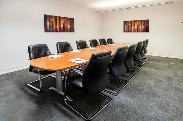 Modern conference room with sleek table and black chairs for professional meetings.