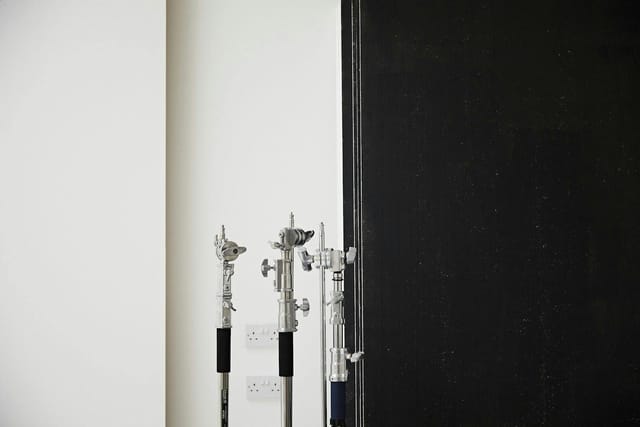 Minimalist portrait studio setup with lighting stands for versatile event production.