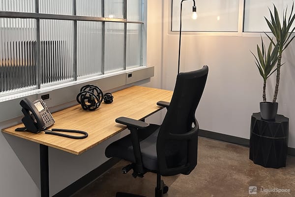 Modern meeting room at Kearny Point with wooden desk, ideal for productive work sessions.