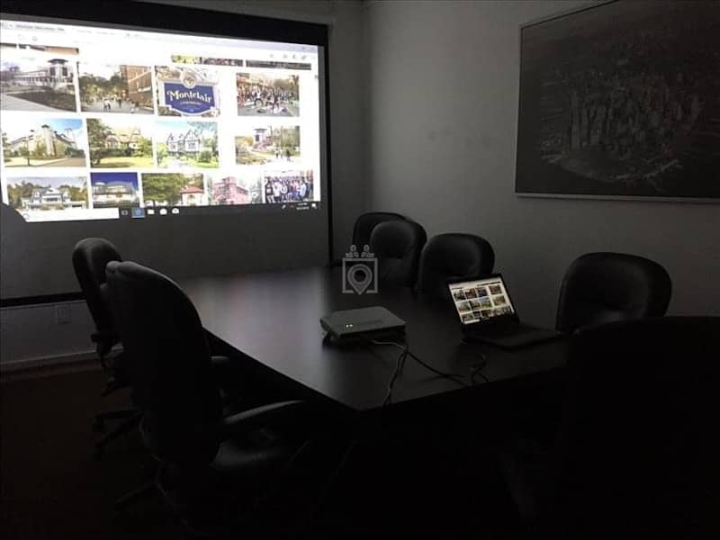 Meeting room with projection screen, ideal for presentations and client pitches.