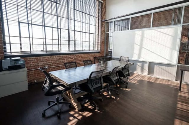 Modern meeting room in HQ Newark with wooden table, ideal for collaborative events.