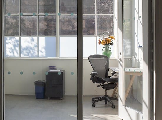 Bright minimalist private office with large windows for meetings and events planning.
