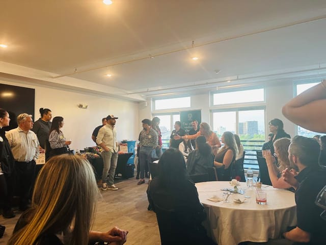 Dynamic networking event at The Sophia Rooftop with engaged attendees and round tables.