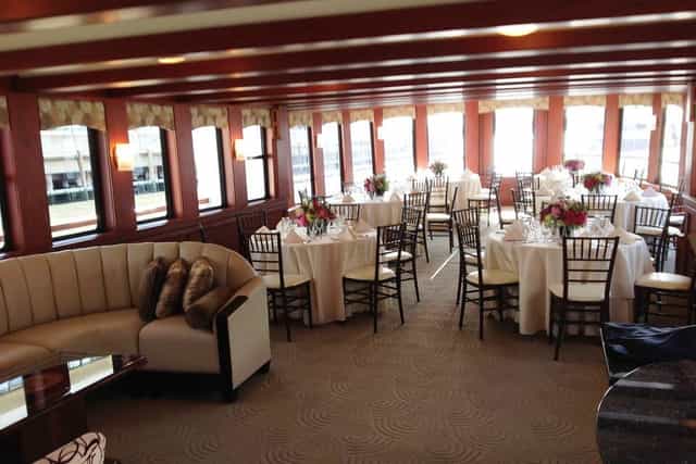 Elegant event space with round tables and floral centerpieces for corporate meetings.