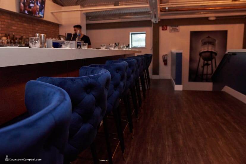 Stylish bar with plush blue seating, ideal for networking events and cocktail receptions.
