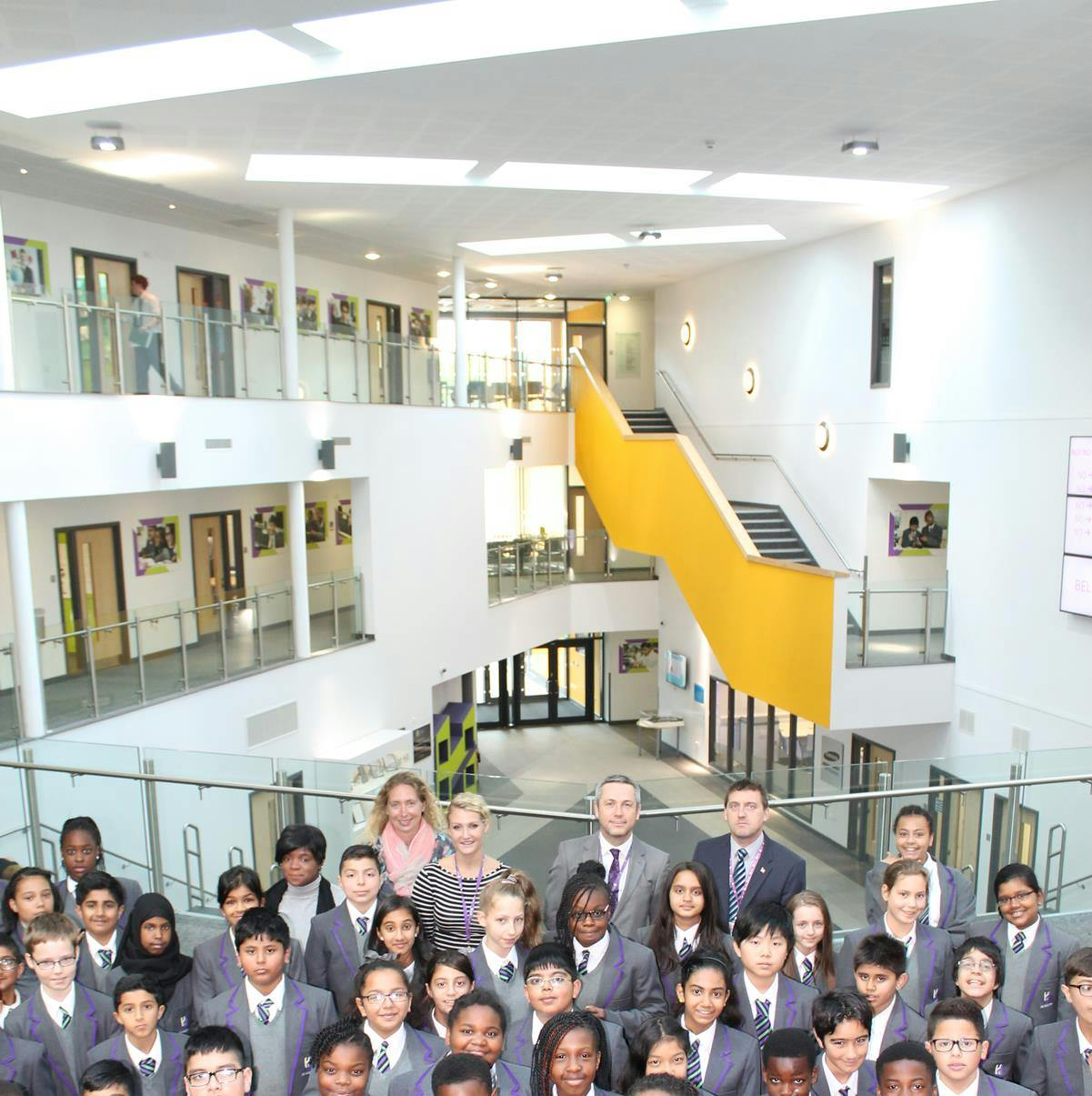 Vibrant students and educators in Harborne Academy's modern Atrium for community events.