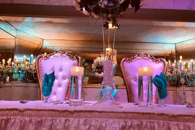Elegant wedding head table with tufted chairs in The Appian Way ballrooms.