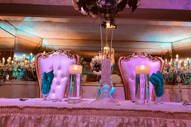Elegant wedding head table with tufted chairs in The Appian Way ballrooms.