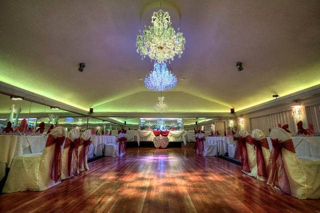 Elegant ballroom with polished wood floor, ideal for weddings and formal events.