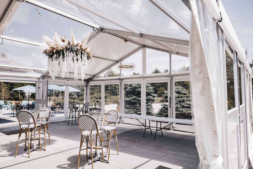 Elegant event space with clear-top tent, ideal for upscale gatherings and meetings.