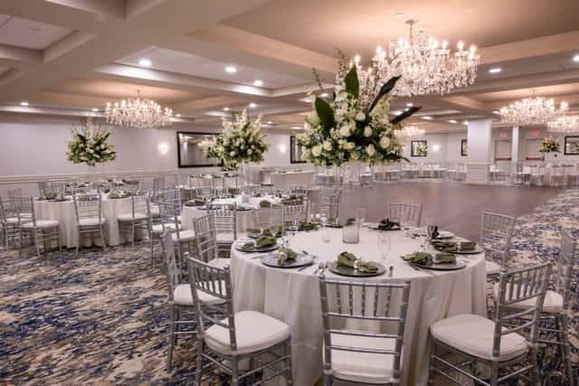 Elegant ballroom with floral centerpieces, perfect for weddings and corporate events.